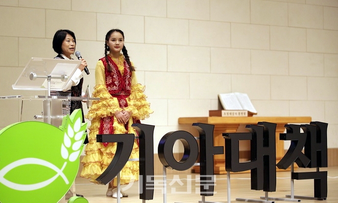 기아대책이 개최한 전국 후원이사 선교대회에서 키르기스스탄 후원 아동 엘리자(오른쪽)와 최진희 기대봉사단이 한국교회에 감사인사를 전하고 있다.