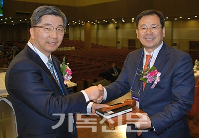 수경노회 직전 노회장 이중식 목사(왼쪽)가 신임 노회장 김용수 목사에게 헌법과 의사봉을 전달하고 있다.
