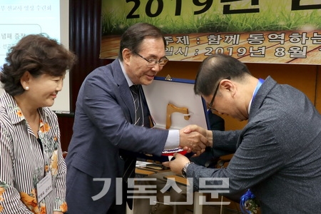 김정훈 이사장으로부터 원로선교사 파송패를 받고 있는 여상일·박영옥 선교사.