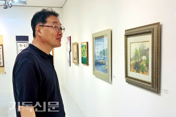 방효성 한국기독교미술인협회 회장이 제54회 한국기독교미술인 협회전 작품을 바라보고 있다.