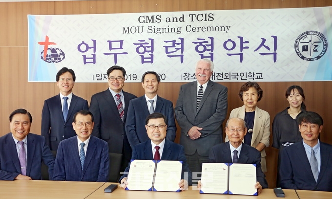 GMS 김정훈 이사장과 TCIS 주영길 이사장이 선교사 자녀 교육을 위한 업무협약서를 작성한 후 양 기관 관계자들과 함께 기념행사를 갖고 있다.