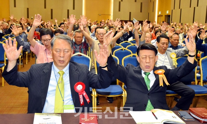 서울지구장로회 회장 이영구 장로를 비롯해 회원부부수련회 참석자들이 두 손을 들고 뜨겁게 기도하고 있다.