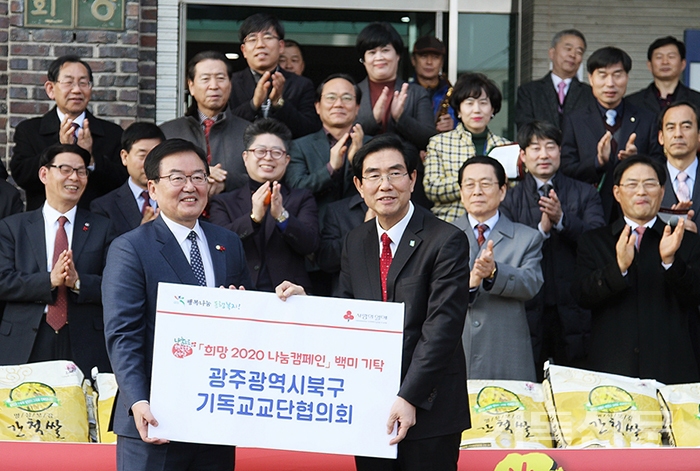 광주북구교단협의회 대표회장 나종갑 목사(사진 오른쪽)가 문인 북구청장에게 사랑의 쌀 1004포를 전달하는 모습.