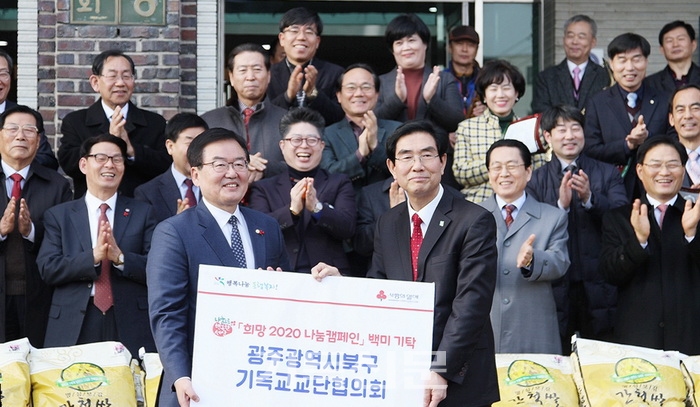 광주북구교단협의회 대표회장 나종갑 목사(오른쪽)가 문인 북구청장에게 사랑의 쌀 1004포를 전달하고 있다.