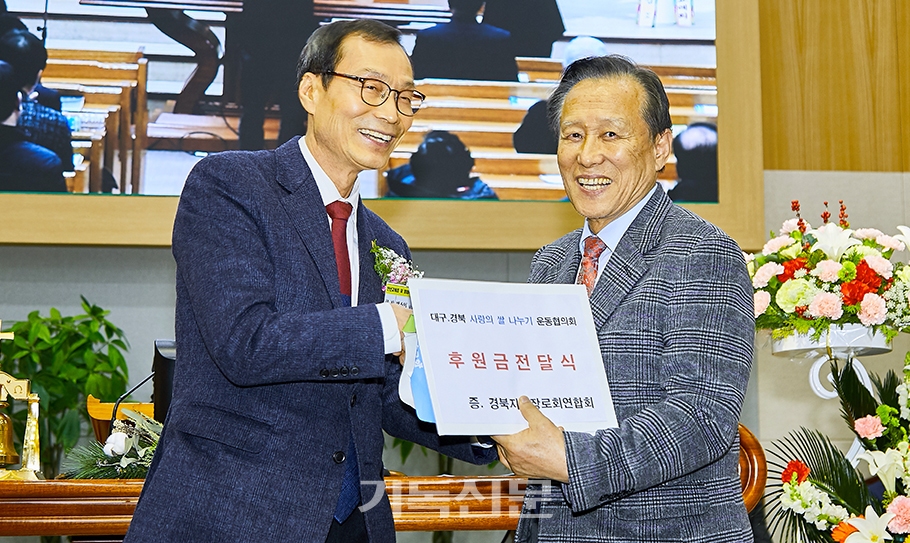 박주일 회장이 대구경북사랑의쌀나누기운동본부 권정식 장로에게 기금을 전달하고 있다.