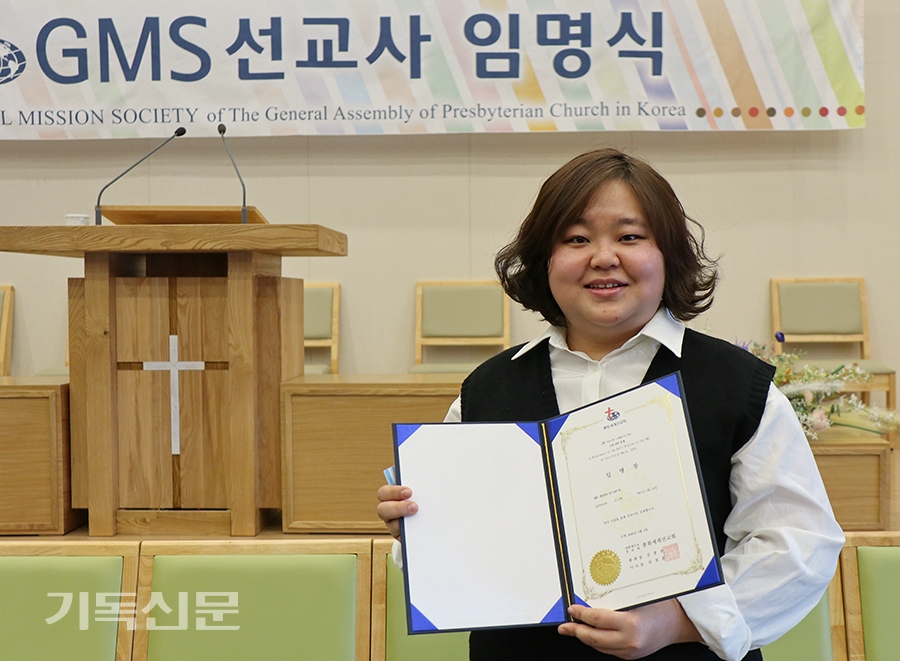 아버지와 더불어 선교사역에 나서는 김신혜 선교사가 신임선교사 임명장을 받고 웃고 있다.