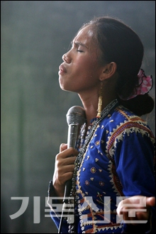 종족 복장을 하고 찬양을 인도하는 자매의 모습.