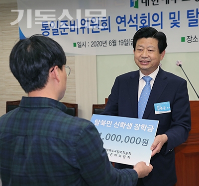 김종준 총회장이 총신신대원에 재학 중인 탈북 신학생 임바울 전도사에게 장학금을 전달하고 있다.