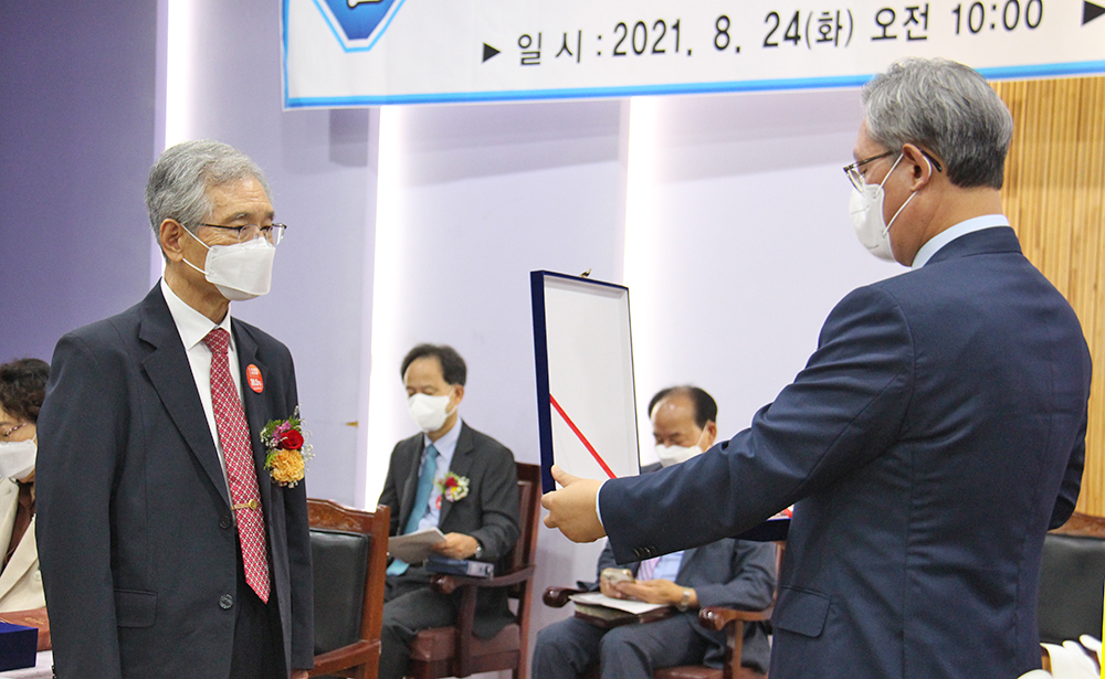 이임하는 정규남 총장에게 법인이사장 김용대 목사가 명예총장 추대패를 전달하고 있다.