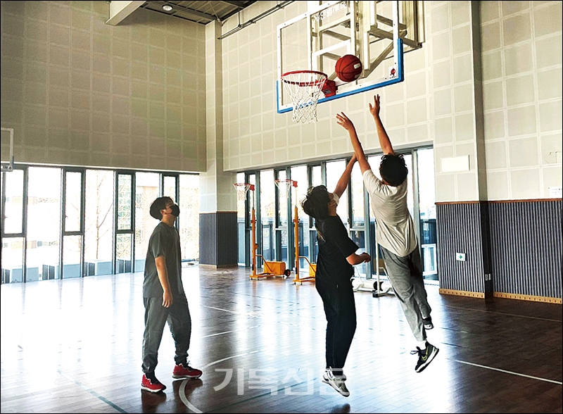 실내체육관에서 농구로 즐거운 시간을 보내고 있는 청소년들.