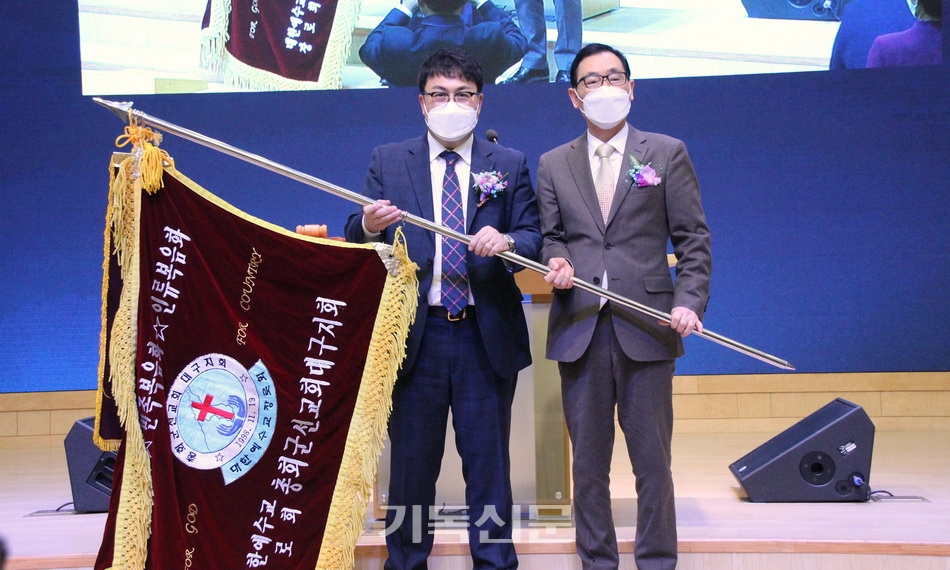 총회군선교회 신임 지회장 박기준 목사(왼쪽)과 이사장 김일영 목사가 회기를 전달받은 후 축하를 받고 있다.