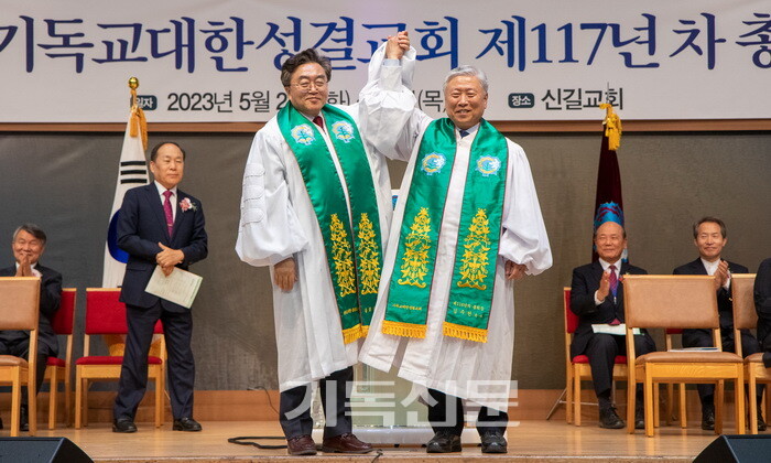 기성 신임 총회장 임석웅 목사(왼쪽)가 직전 총회장 김주헌 목사와 함께 손을 들어보이고 있다.