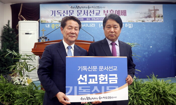 반월교회 오동환 목사(오른쪽)가 태준호 사장에게 기독신문 문서선교 헌금을 전달하고 있다. 