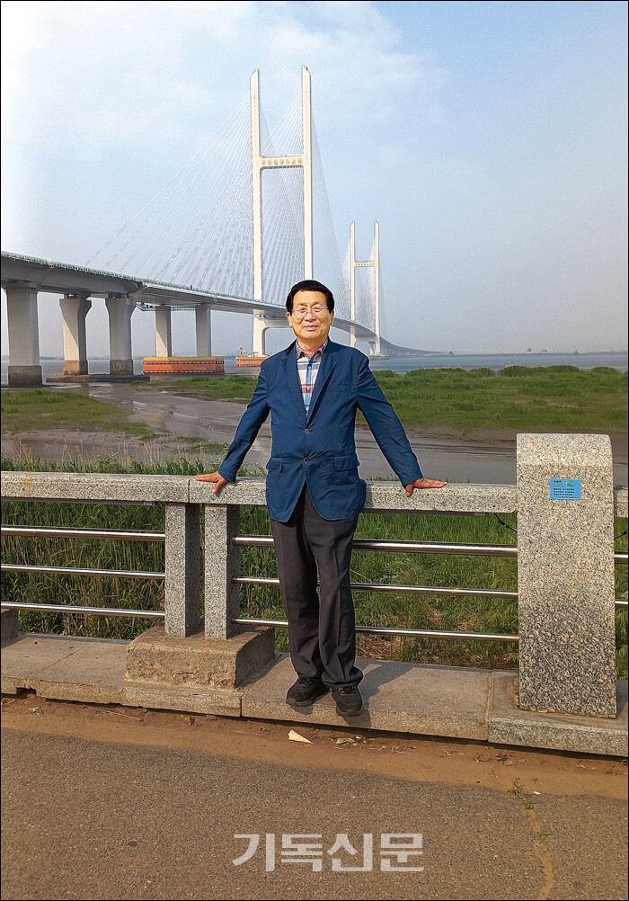 [북한의 섬] 집필을 위해 답사를 나선 이재언 목사가 북한과 중국 접경인 신의주대교 앞에 서 있다. 한반도 북녘의 유인도 128개 섬의 이야기를 소개한 [북한의 섬] 표지.(사진 위)
