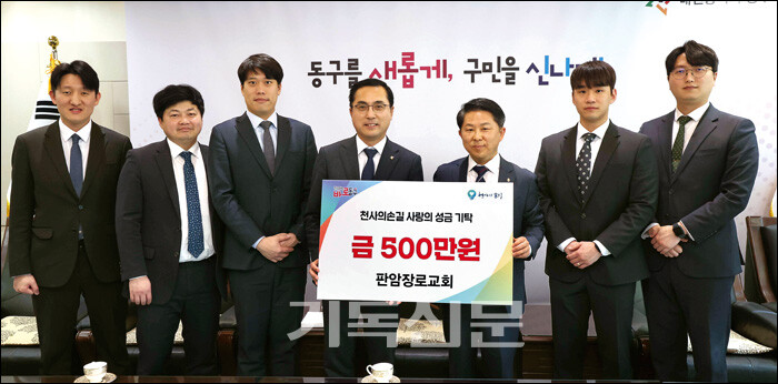 홍성현 목사(오른쪽 세 번째)가 박희조 대전 동구청장(네 번째)에게 불우 청소년 교복비를 지원하고 있다.