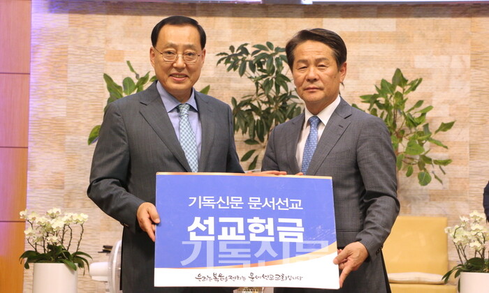 삼호교회 이형만 목사(왼쪽)가 기독신문사장 태준호 장로에게 문서선교 후원금을 전달하고 있다.