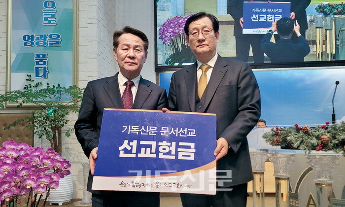 영광대교회 김용대 목사(오른쪽)가 기독신문 태준호 사장 에게 문서선교헌금을 전달하고 있다. 