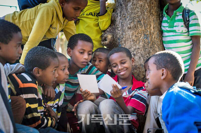 후원자의 편지를 보는 에티오피아 컴패션 아이들이 웃음을 짓고 있다.