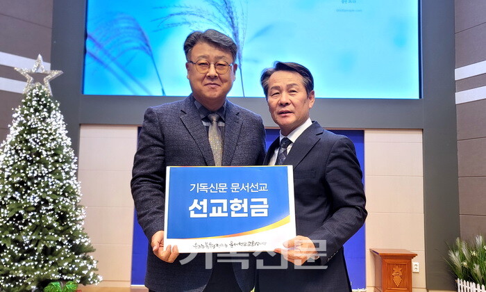 ​명성교회 김종혁 목사(왼쪽)가 기독신문 태준호 사장에게 문서선교헌금을 전달하고 있다.