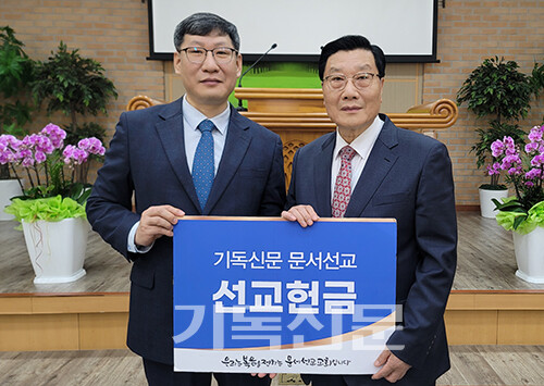  곡성은혜교회 신승우 목사(사진 왼쪽)가 기독신문 50번째 문서선교 교회를 감사하며 이사장 김정설 목사에게 문서선교헌금을 전하고 있다.