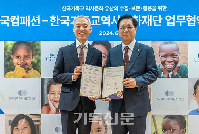 한국컴패션 대표 서정인 목사(사진 왼쪽)와 한국기독교역사문화재단 이사장 이영훈 목사가 양해각서를 들고 환하게 웃고 있다.