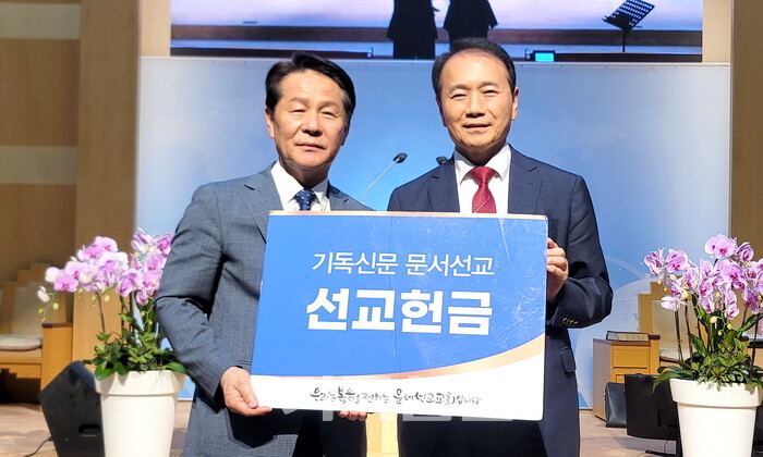 상계제일교회 이장연 목사(오른쪽)가 태준호 사장에게 문서선교헌금을 전달하고 있다.