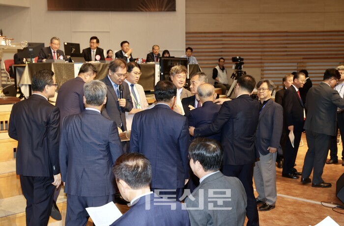 정년연장 헌의안이 정치부 보고대로 처리되려 하자, 총대들이 반대하며 단상 앞에서 이의를 제기하고 있다. 