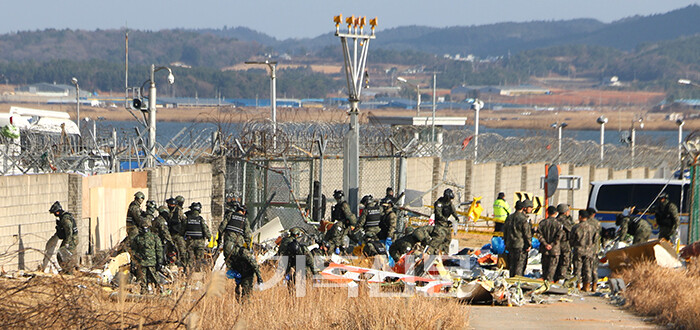 비극적인 참사현장과, 활주로 주변에서 희생자 시신을 수색하고 수습 중인 군경들 모습.