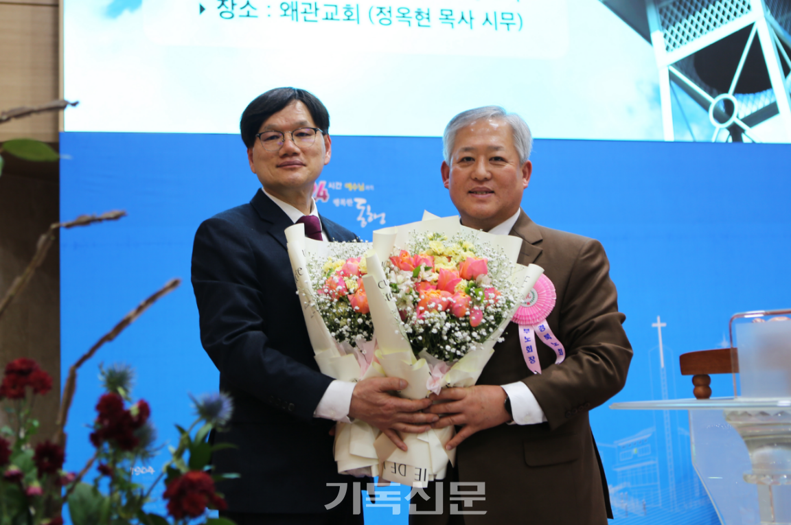 경북노회 노회장 송종필 목사가 제110회 총회 부회록서기에 후보추천 된 이도형 목사에게 꽃다발을 전달하고 있다.