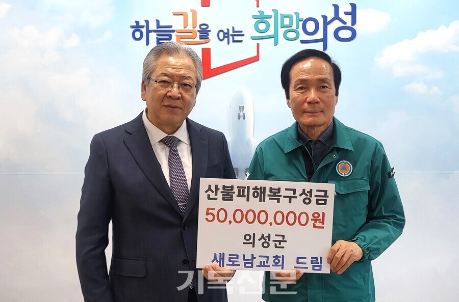 새로남교회 오정호 목사(사진 왼쪽)가 최악의 산불 피해를 입은 경북 의성군 주민들을 위한 지원금 5000만원을 김주수 군수에게 전하고 있다.