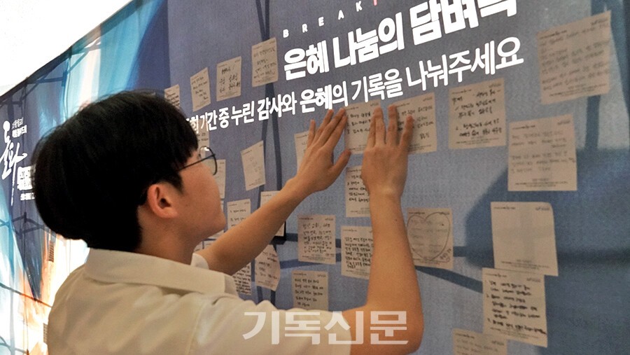 한 성도가 교회 통로에 설치된 벽에 기도 응답을 적어 붙이고 있다. 성도들은 수시로 기도의 간증을 기록해 나누며 힘을 얻고 있다.