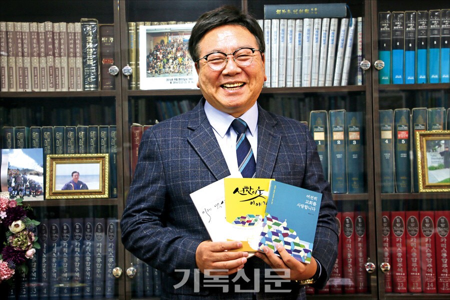 윤창규 목사가 자신의 목회 여정과 신앙 고백을 담은 저서를 들고 환하게 웃고 있다. 윤 목사는 교모세포종 4기 수술 이후에도 “하나님 사랑, 이웃 사랑의 실천이 교회의 사명”이라며 목회 30주년의 은혜를 간증하고 있다.