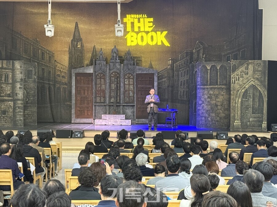 아가페컬처 설립을 기념하며 열린 뮤지컬 '더 북' 상연무대에서 이사장 이상복 목사가 인사하고 있다.