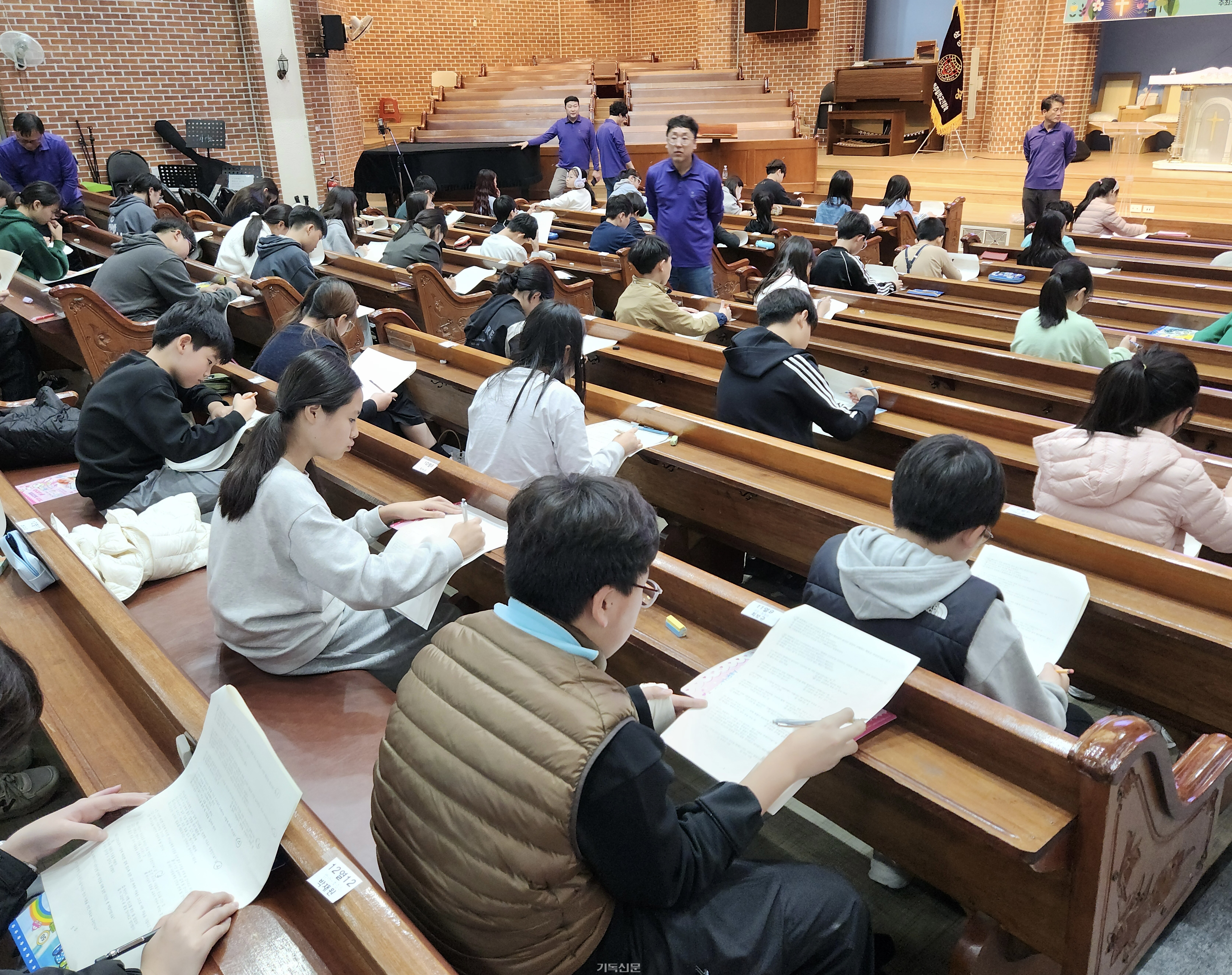 제27회 성경고사대회에서 문제지를 받은 참석자들이 고심하며 성경 고사를 치르고 있다.