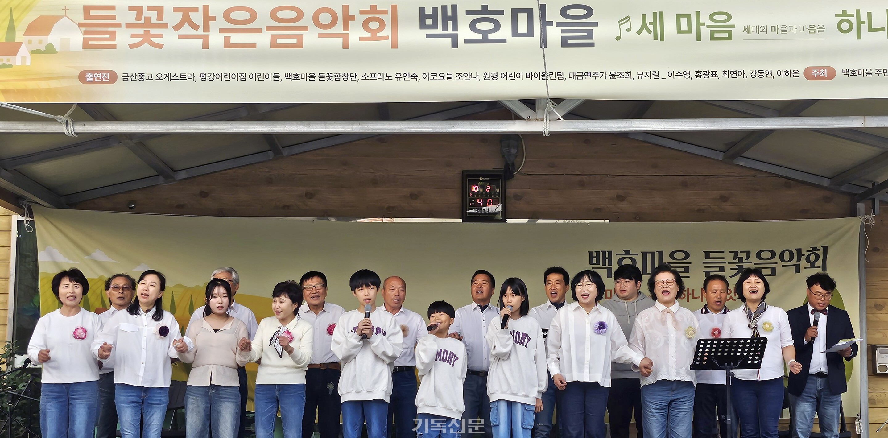 김제 들꽃교회와 백호마을이 함께 꾸미는 들꽃작은음악회에서 여러 세대가 함께하는 들꽃합창단이 활기찬 무대를 선보이고 있다.