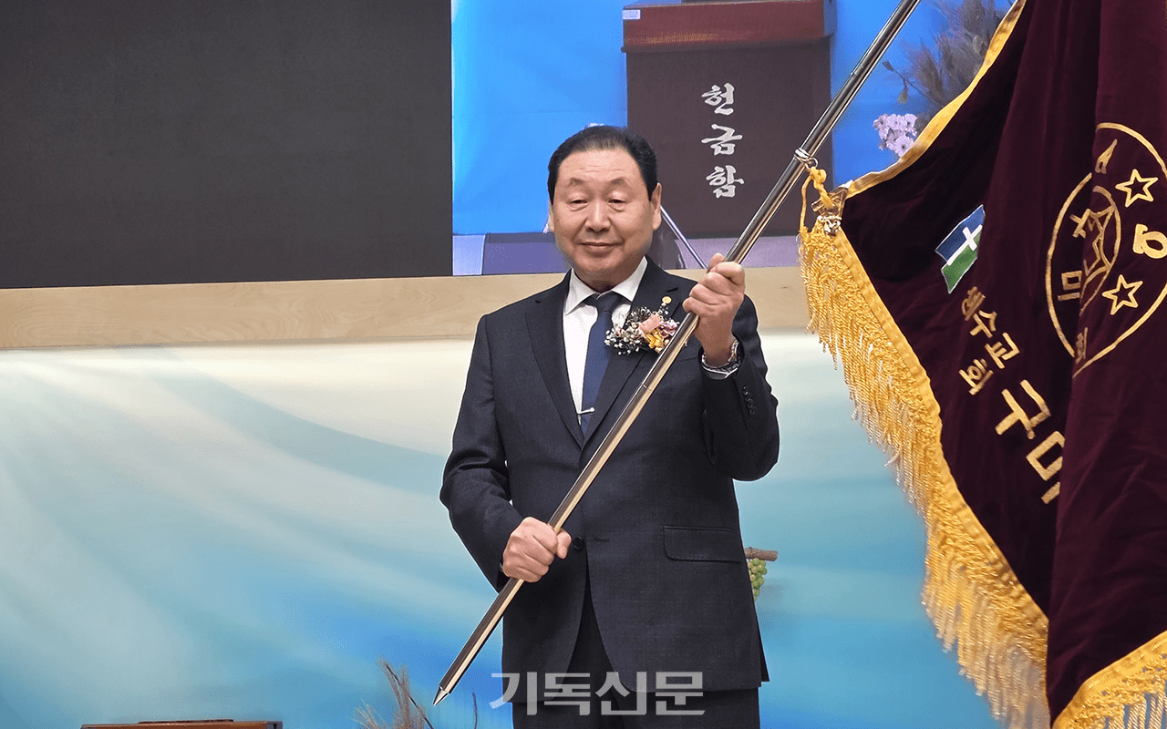 구미장로회 신임 회장으로 선출된 전희식 장로가 회기를 흔들며 모범적인 장로회를 만들 것을 다짐하고 있다.
